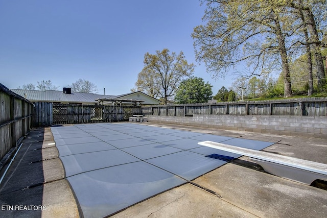 view of pool with a fenced backyard, a diving board, a patio area, and a fenced in pool