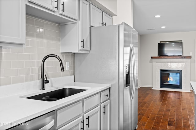 8411 Ivy Green Way, Knoxville, TN 37919 - kitchen featuring a sink, tasteful backsplash, light countertops, a fireplace, and appliances with stainless steel finishes
