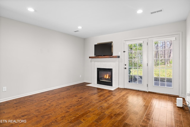 8411 Ivy Green Way, Knoxville, TN 37919 - unfurnished living room featuring a fireplace with flush hearth, baseboards, wood finished floors, and visible vents