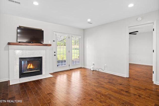 8411 Ivy Green Way, Knoxville, TN 37919 - unfurnished living room featuring baseboards, hardwood / wood-style flooring, visible vents, and a tiled fireplace