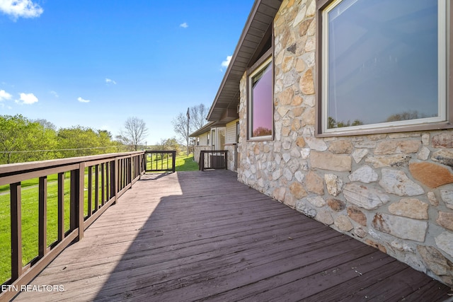 wooden terrace featuring a lawn