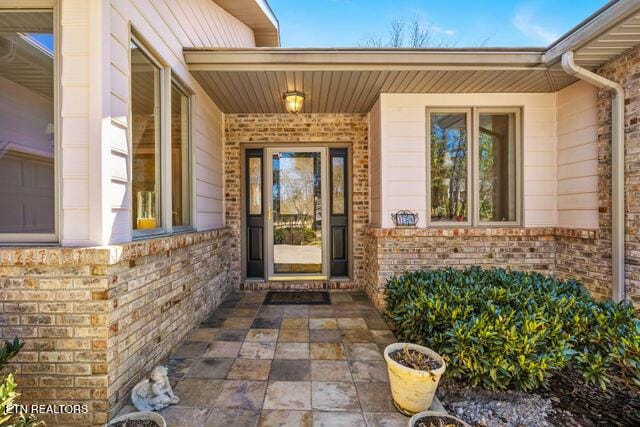 doorway to property featuring brick siding