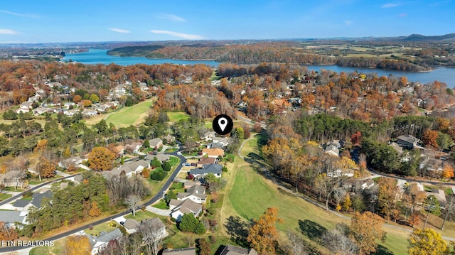 drone / aerial view with view of golf course, a residential view, and a water view