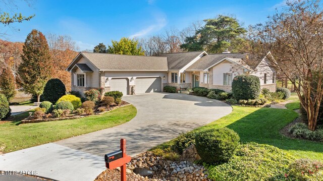 ranch-style home with an attached garage, a front yard, and concrete driveway