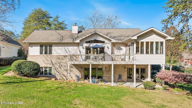 rear view of house featuring a patio area, a chimney, french doors, a yard, and a wooden deck