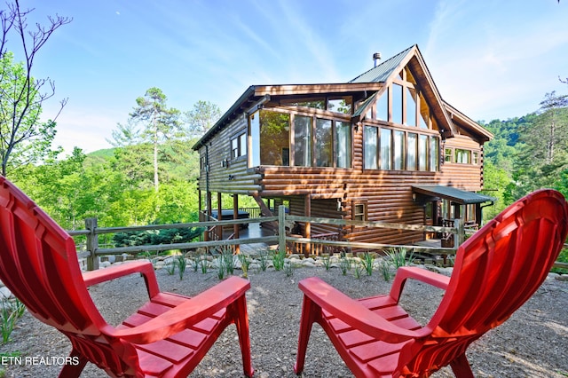 rear view of house featuring log siding
