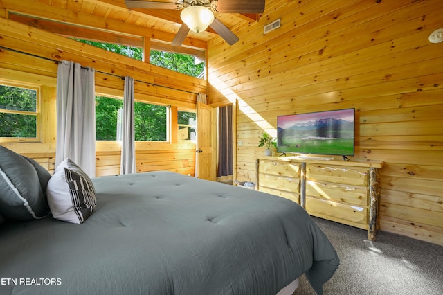 bedroom featuring beam ceiling, access to exterior, visible vents, wooden walls, and carpet floors