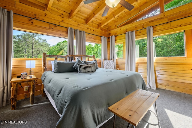 bedroom with wooden walls, carpet, vaulted ceiling with beams, and wood ceiling