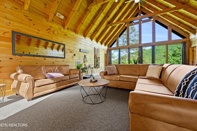 living area with wooden walls, carpet floors, beam ceiling, and high vaulted ceiling