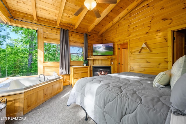 carpeted bedroom featuring wooden walls, a glass covered fireplace, wood ceiling, and lofted ceiling with beams