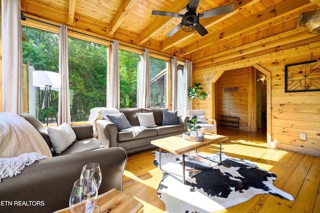 living area with plenty of natural light, beam ceiling, and wood ceiling