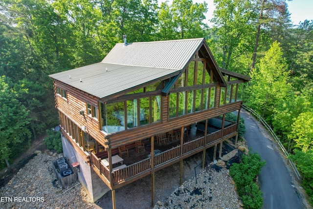 rear view of house with metal roof and a deck