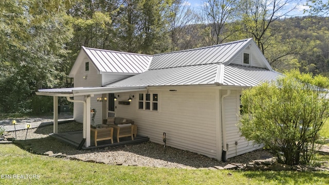back of house featuring a standing seam roof and metal roof