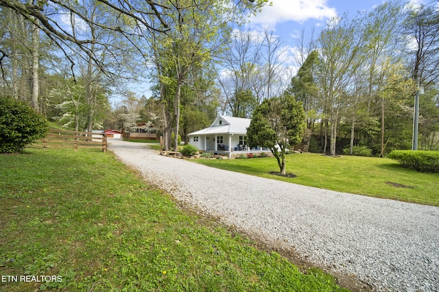 surrounding community featuring gravel driveway and a yard