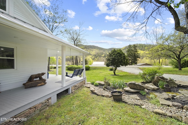 view of yard featuring a porch and a mountain view
