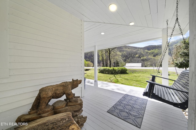 wooden deck with a lawn and a mountain view