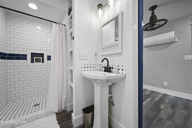 bathroom featuring baseboards, a shower with curtain, wood finished floors, and a wall unit AC