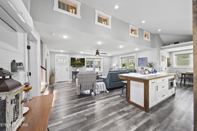 kitchen featuring dark wood-style floors, open floor plan, recessed lighting, white cabinetry, and light countertops