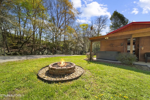 view of yard featuring an outdoor fire pit and a hot tub