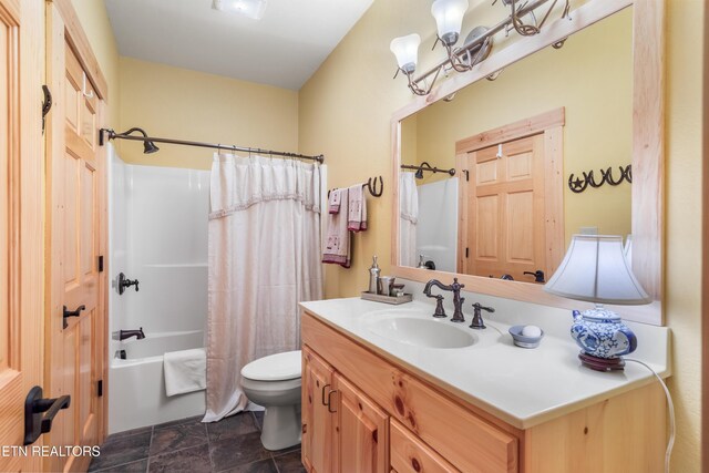 full bathroom with stone finish floor, toilet, shower / bathtub combination with curtain, vanity, and a notable chandelier