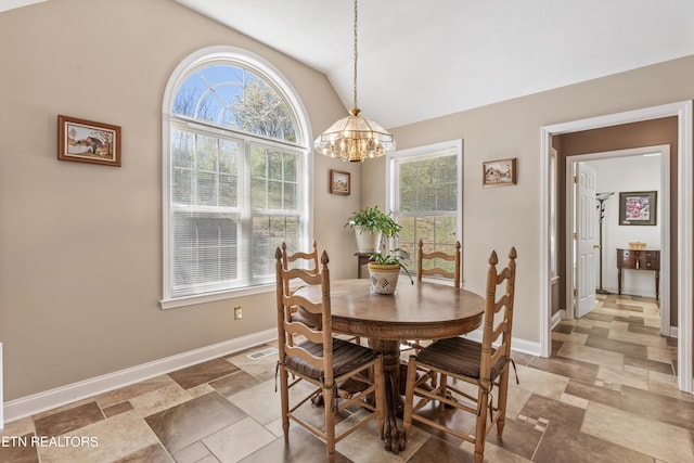 dining space featuring vaulted ceiling, visible vents, baseboards, an inviting chandelier, and stone finish flooring