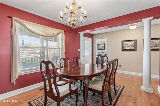 dining space with light wood-style flooring, baseboards, ornate columns, and a healthy amount of sunlight