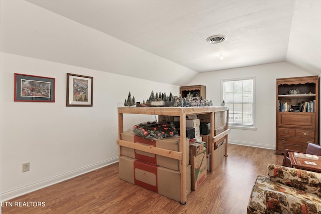 bedroom with light wood-type flooring, baseboards, vaulted ceiling, and visible vents