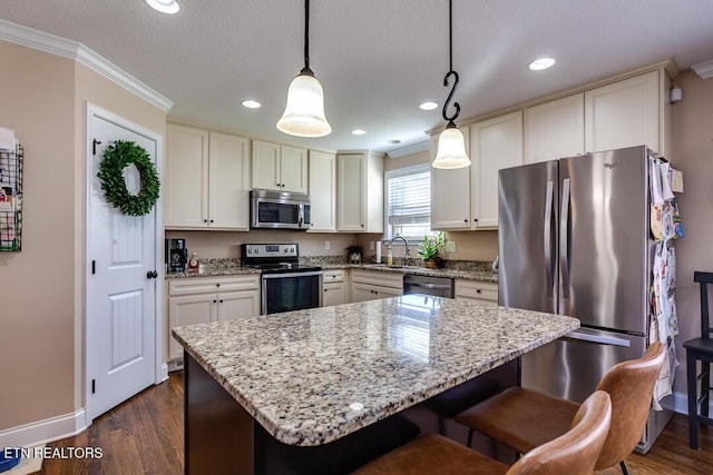 kitchen with light stone counters, ornamental molding, dark wood-type flooring, and stainless steel appliances