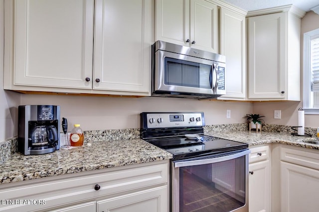 kitchen with white cabinets, light stone countertops, and appliances with stainless steel finishes