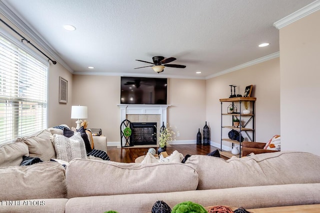 living area featuring recessed lighting, wood finished floors, baseboards, a tiled fireplace, and ceiling fan
