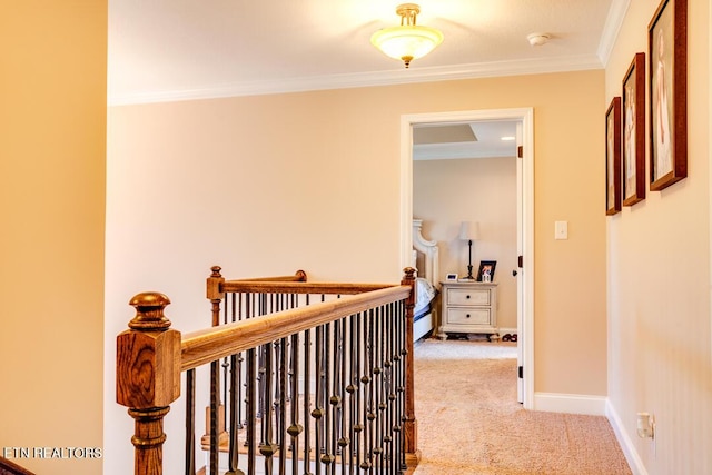 hall featuring carpet floors, crown molding, baseboards, and an upstairs landing