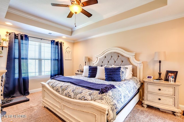 bedroom featuring light carpet, ornamental molding, visible vents, and a raised ceiling