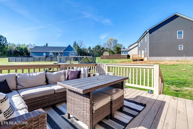 wooden deck featuring a fenced backyard, a lawn, and an outdoor hangout area