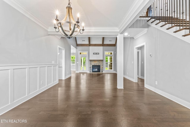 1416 Ebenezer Rd, Knoxville, TN 37922 - unfurnished living room featuring ornamental molding, dark wood-style floors, a stone fireplace, and a chandelier