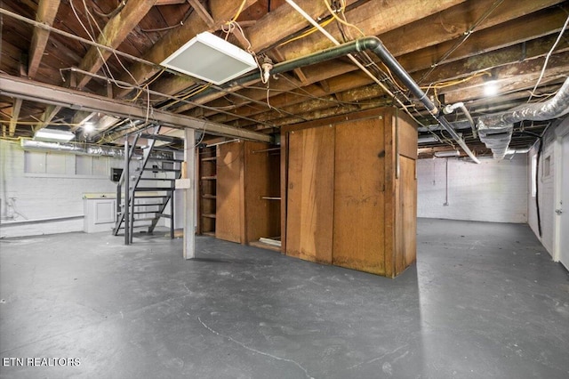 unfinished basement featuring stairway