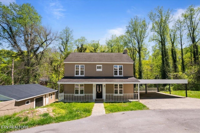 farmhouse with a carport, aphalt driveway, and covered porch