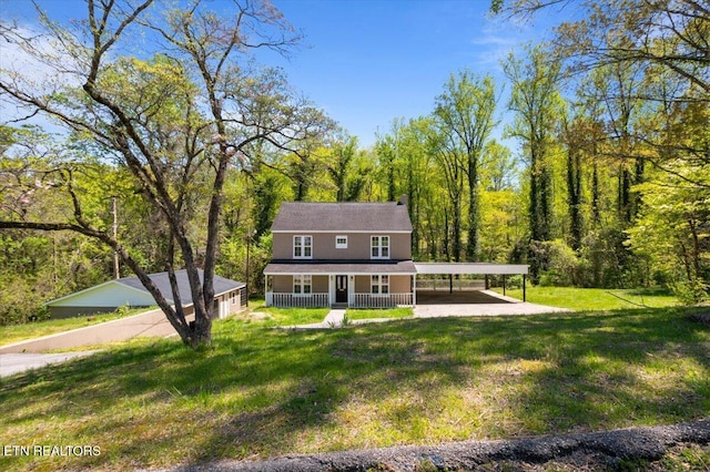view of front of house with a view of trees, a porch, and a front lawn
