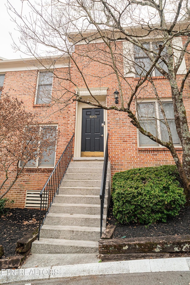 view of exterior entry featuring brick siding