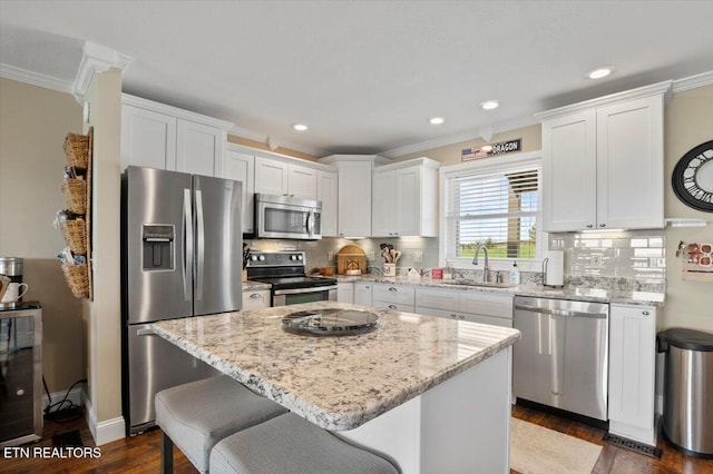 470 Deerfield Lndg Unit 5, Lafollette, TN 37766 - kitchen featuring a center island, a sink, appliances with stainless steel finishes, white cabinets, and ornamental molding