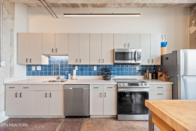 kitchen featuring decorative backsplash, a sink, stainless steel appliances, and light countertops