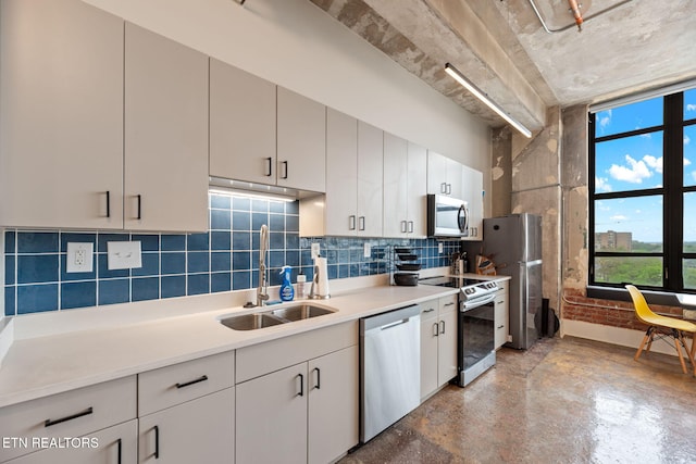 kitchen with a sink, concrete flooring, stainless steel appliances, tasteful backsplash, and light countertops