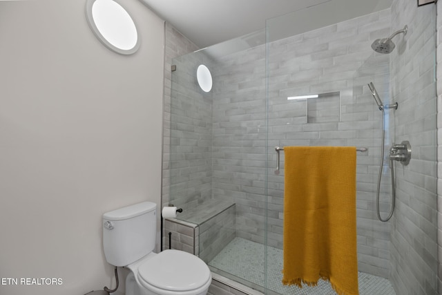 bathroom featuring a shower stall and toilet
