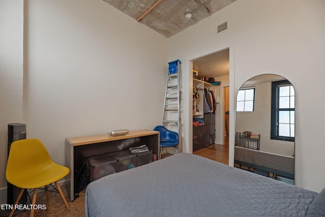 bedroom with visible vents, a spacious closet, arched walkways, and a closet