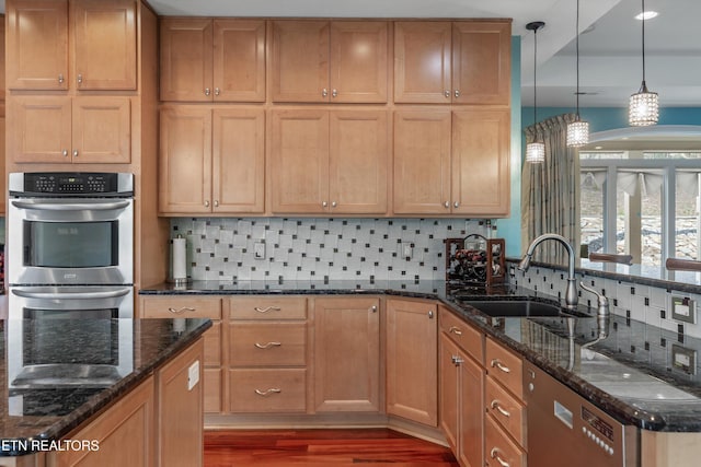 kitchen featuring double oven, wood finished floors, dishwashing machine, a sink, and decorative backsplash