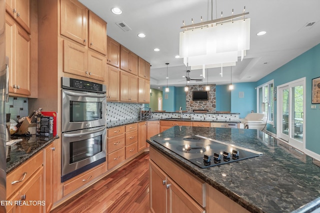 kitchen featuring black electric cooktop, visible vents, decorative backsplash, wood finished floors, and double oven