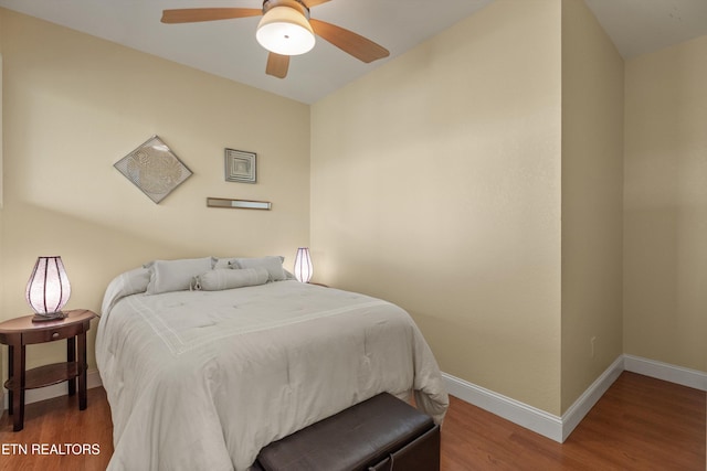 bedroom featuring wood finished floors, a ceiling fan, and baseboards