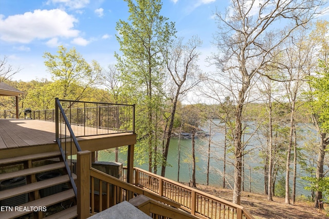 wooden deck featuring stairs and a water view