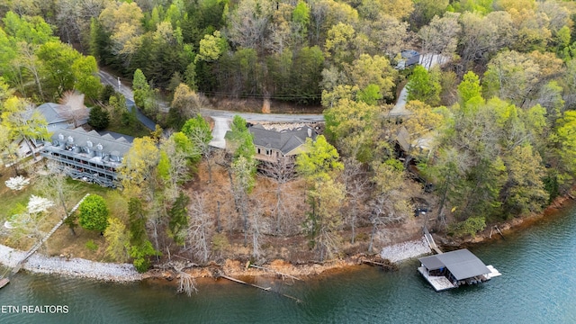 bird's eye view featuring a wooded view and a water view