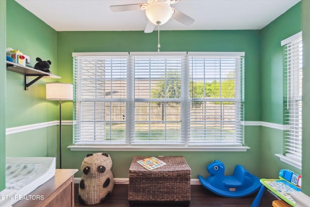 rec room featuring wood finished floors, a ceiling fan, and baseboards