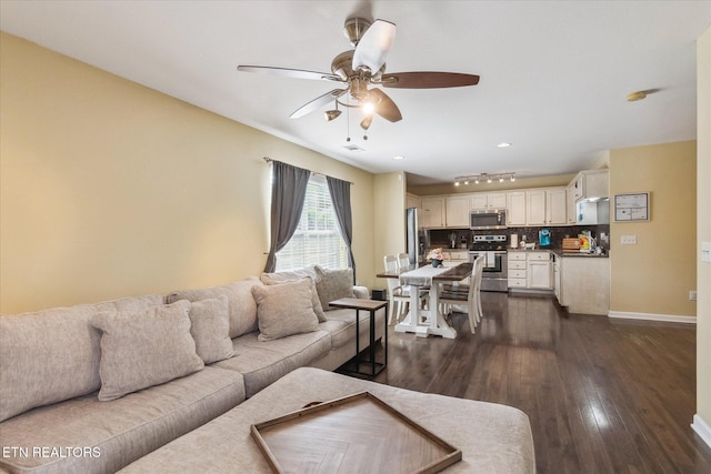 living area featuring dark wood finished floors, baseboards, and a ceiling fan